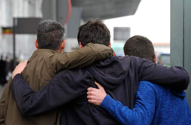 People comfort each other as they arrive at the Barcelona airport.