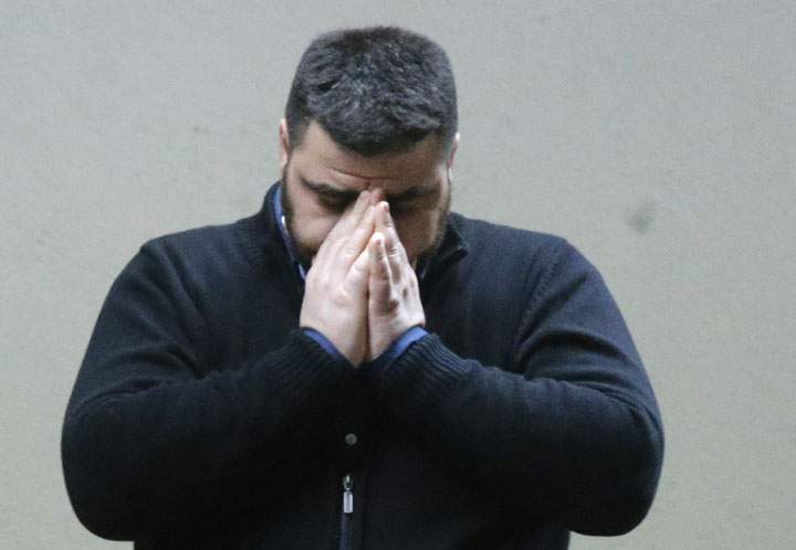 A man who appears to have waited for the missing flight 4U 9525 covers his face at the airport in Duesseldorf, Germany on Tuesday, March 24, 2015. A Germanwings passenger jet carrying 148 people crashed in the French Alps region. The flight was travelling from Barcelona to Duesseldorf.