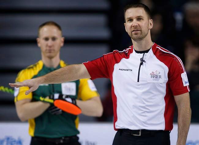 Newfoundland and Labrador skip Brad Gushue, right, gestures to his teammates as Northern Ontario skip Brad Jacobs looks on during curling action at the Brier.
