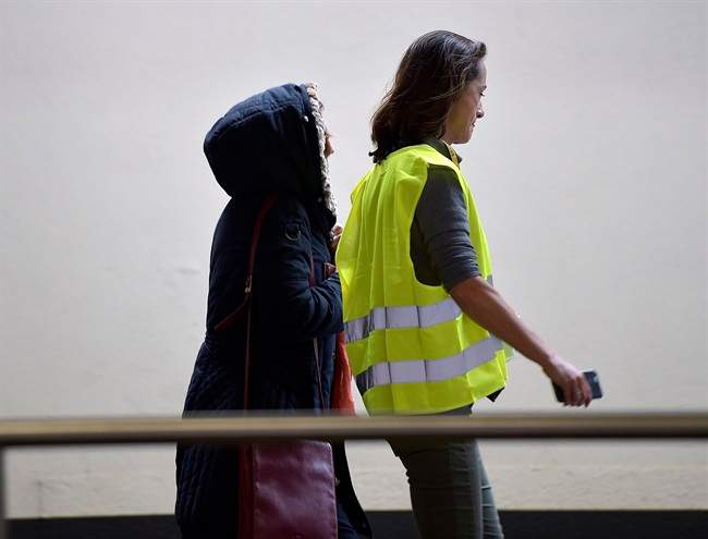 A woman is led to a closed area for relatives of a plane crash at the airport in Duesseldorf, Germany, Tuesday, March 24, 2015 after a Germanwings passenger jet carrying more than 140 people crashed in the French Alps region as it traveled from Barcelona to Duesseldorf.