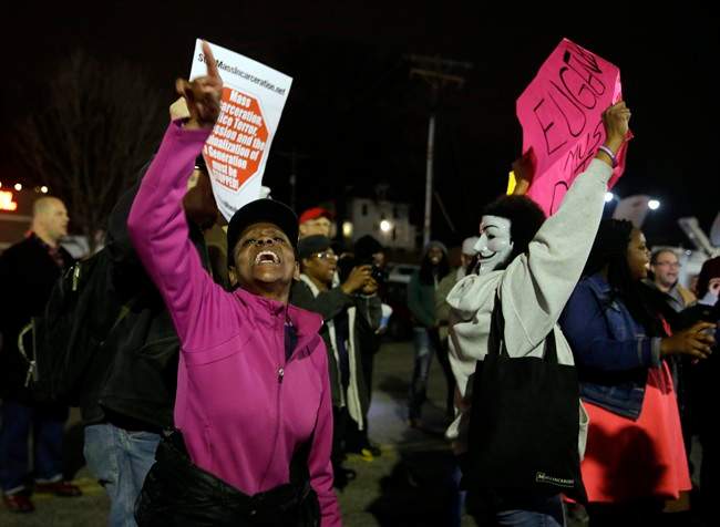 People demonstrate across the street from the Ferguson Police Department, Thursday, March 12, 2015, in Ferguson, Mo. 