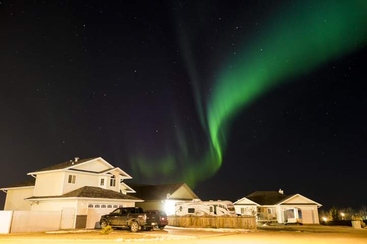 A ribbon of aurorae move across the sky in Lac La Biche, Alberta.