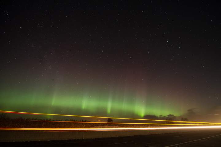 The aurora dance as a truck passes on the highway, north of Colborne, Ontario.