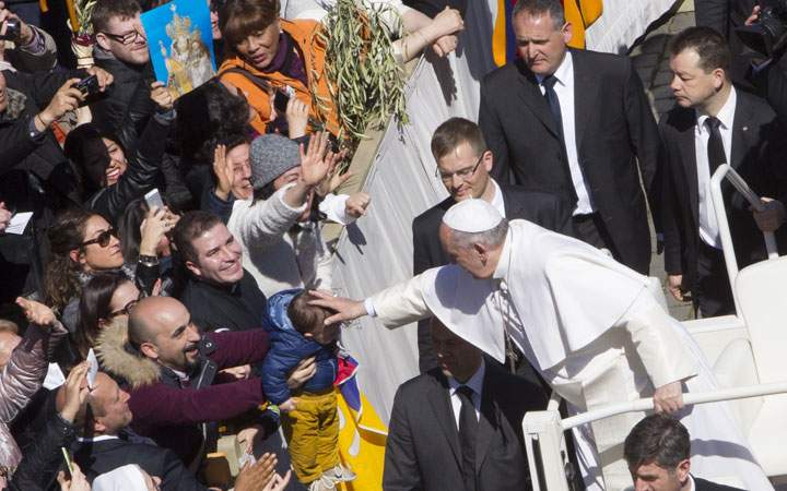 Pope Francis blesses a baby after celebrating a Palm Sunday Mass in St. Peter's Square, at the Vatican, Sunday, March 29, 2015. 
