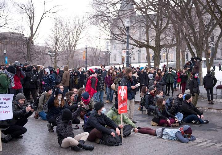 Demonstrators sit on the street at an anti-austerity protest, Thursday, March 26, 2015 in front of the legislature in Quebec City.