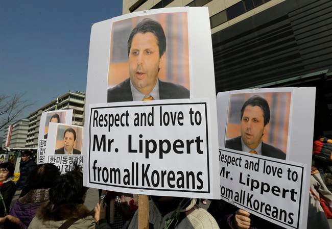 South Korean conservative activists hold portraits of U.S. Ambassador to South Korea Mark Lippert during a rally demanding his quick recovery near the U.S. embassy in Seoul, South Korea, Friday, March 6, 2015. A knife attack on Thursday that injured Lippert is the latest act of political violence in a deeply divided country where some protesters portray their causes as matters of life and death. 