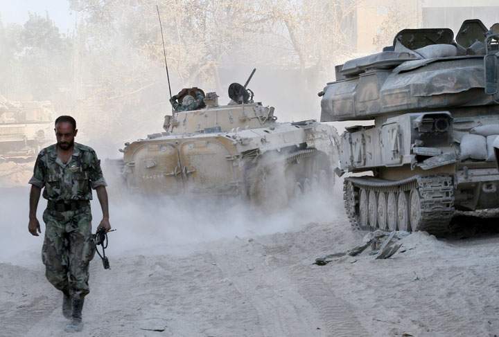 In this photo taken on a government-organized media tour, a Syrian army soldier walks on a street in Damascus, Syria, Saturday, Aug. 24, 2013. 