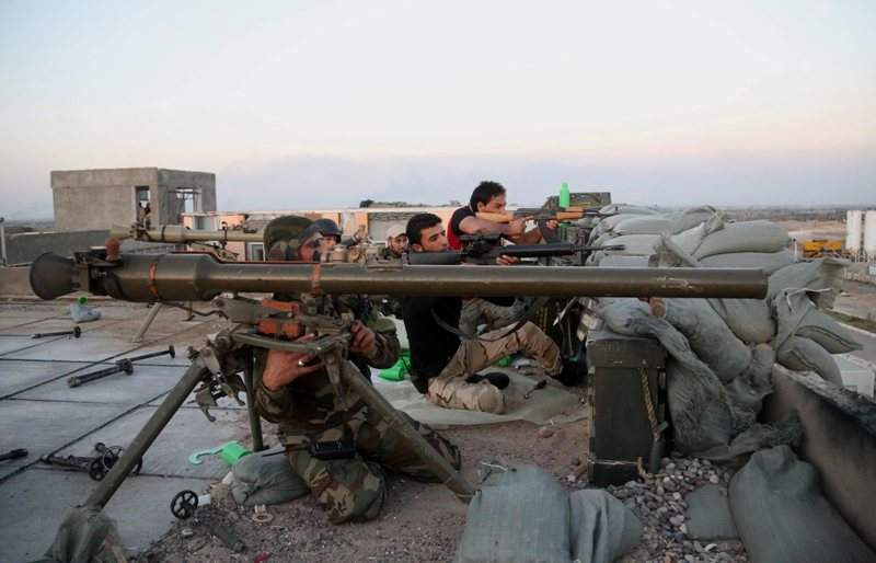Iraqi security forces and allied Shiite militiamen clash with Islamic State fighters at the front line in the Qadisiyah neighborhood in Tikrit, 130 kilometers (80 miles) north of Baghdad, Iraq, Sunday, March 15, 2015.