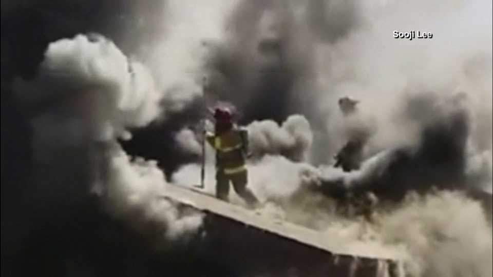 Footage shows firefighter fall through burning roof