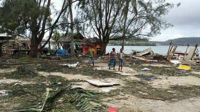In this photo provided by China’s Xinhua News Agency, locals walk past debris in Port Vila, Vanuatu, after Cyclone Pam ripped through the tiny South Pacific archipelago, Sunday, March 15, 2015. Packing winds of 270 kilometers (168 miles) per hour, Cyclone Pam tore through Vanuatu early Saturday, leaving a trail of destruction.