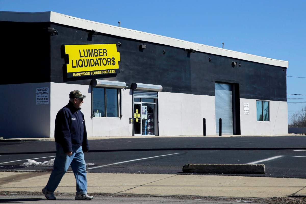 A man walks past a Lumber Liquidators store, Thursday, March 12, 2015, in Philadelphia. The Justice Department is pursuing criminal charges against the retailer.
