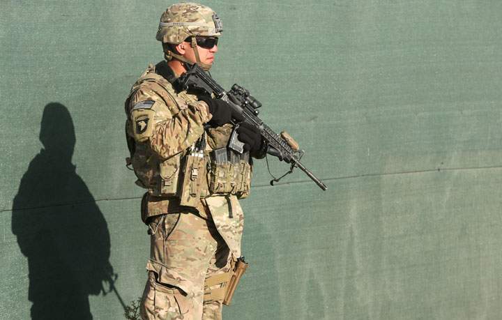 An International Security Assistance Force stands guard during a flag-lowering ceremony in Kabul, Afghanistan, Monday, Dec. 8, 2014.