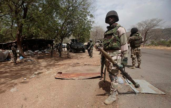 FILE - In this file photo taken Wednesday, April 8, 2015, Nigerian Soldiers man a check point in Gwoza, Nigeria, a town newly liberated from Boko Haram.