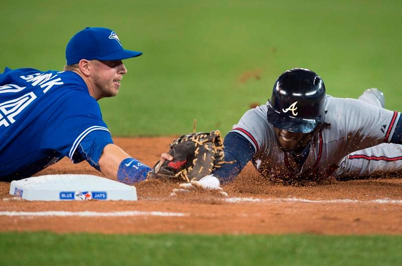 Toronto Blue Jays' Justin Smoak, left, tags out Atlanta Braves' Cameron Maybin to complete an unassisted double play during seventh inning interleague baseball action in Toronto on Sunday, April 19, 2015. 