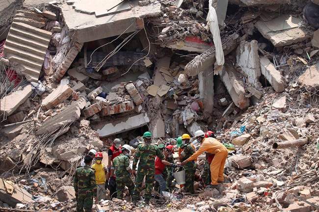 Workers try to release two bodies trapped in the rubble of collapsed Rana Plaza garment factory building in Savar, near Dhaka, Bangladesh, April 30, 2013. (File photo).