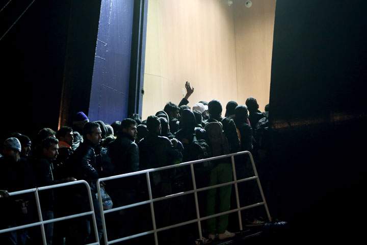 Immigrants board a ship in the port of Lesvos island by destination to Athens on April 17, 2015.
