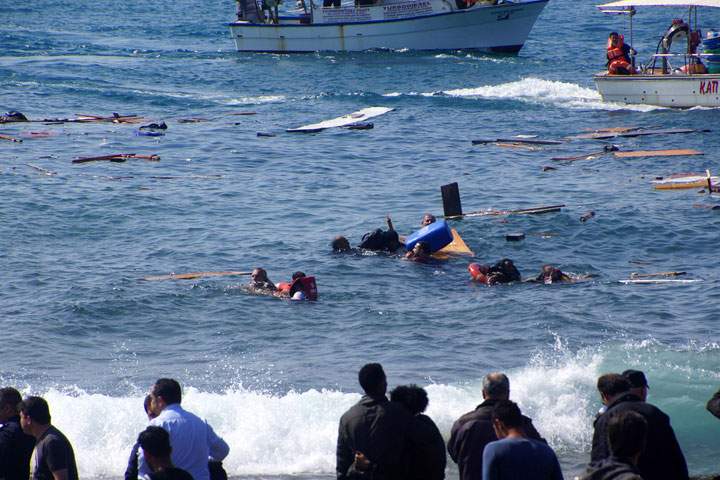 Local residents and rescue workers try to help migrants after their boat sank off the island of Rhodes, southeastern Greece, on April 20, 2015.