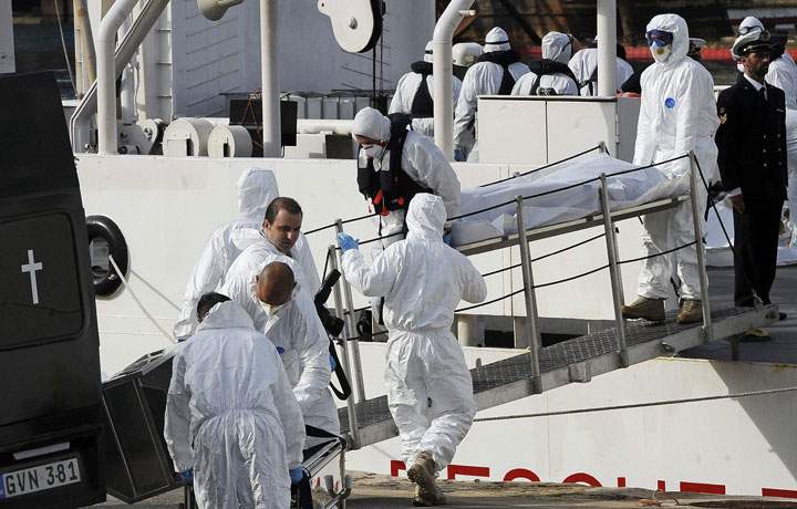 Italian Coast Guard officers disembark the body of a migrant off the ship Bruno Gregoretti, in Valletta’s Grand Harbour, Monday, April 20 2015.