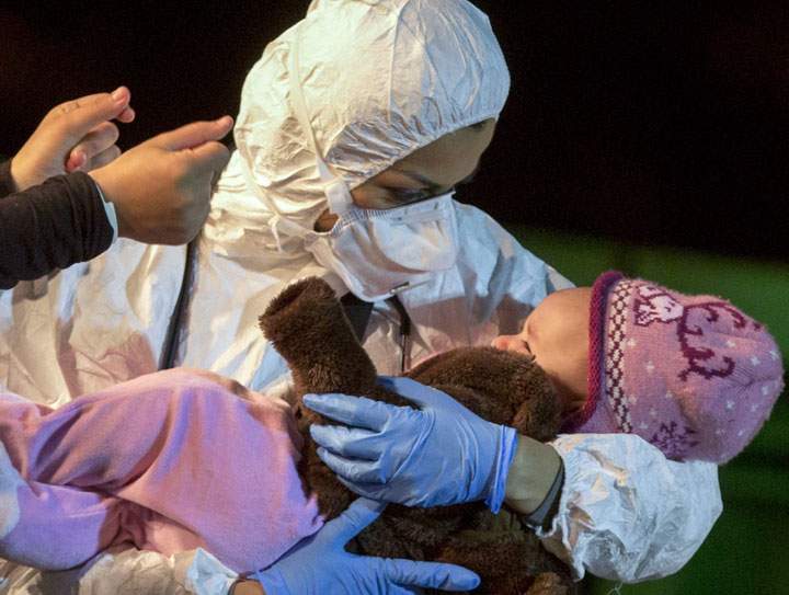 A rescuer cradles a child in the Sicilian harbor of Pozzallo, Italy, early Monday, April 20, 2015.