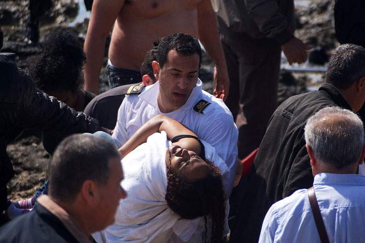 A man carries a woman as local residents and rescue workers help migrants after their boat sank off the island of Rhodes, southeastern Greece, on April 20, 2015.