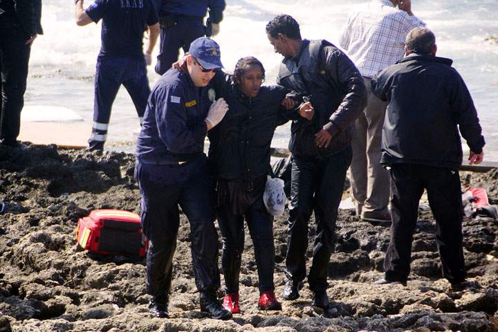 Greek coast guards help a woman rescued after a boat carrying migrants sank off the island of Rhodes, southeastern Greece, on April 20, 2015.