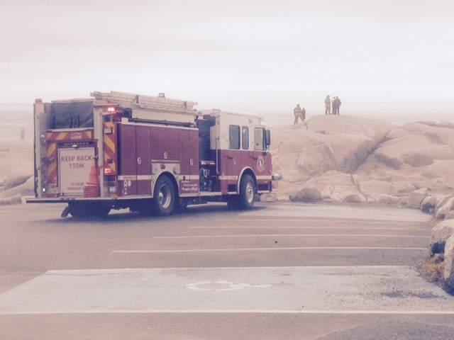 A fire truck sits near rocks where emergency crews work on search and rescue efforts in Peggys Cove, N.S.
