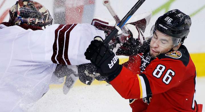 Arizona Coyotes' goalie Mike Smith, left, takes a roughing penalty on Calgary Flames' Josh Jooris during third period NHL action in Calgary, Alta., Tuesday April 7, 2015. 