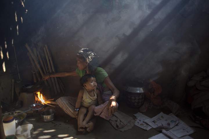 In this Tuesday, March 31, 2015 photo, an elderly Indian woman cooks using firewood at her home at Gobhali village on the outskirts of Gauhati, India.