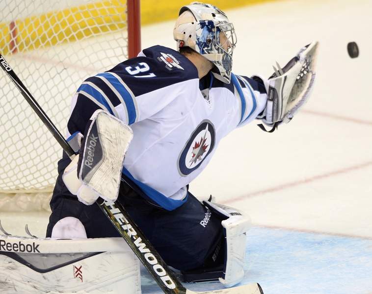 Winnipeg Jets' goalie Ondrej Pavelec (31), of Czech Republic, makes a glove save against the St. Louis Blues during the third period of an NHL hockey game, Tuesday, April 7, 2015, in St. Louis. 