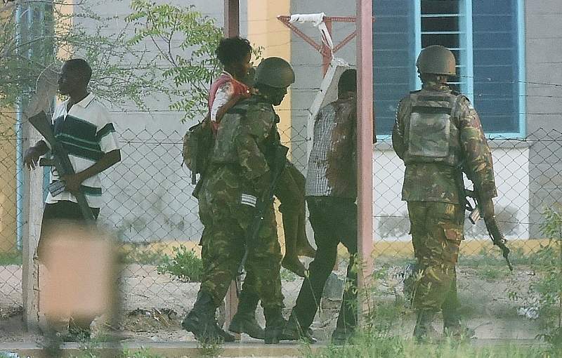 A female student hostage is escorted out of Garissa University after Kenya Defence Forces ended a siege by terrorist gunmen on April 2, 2015.
