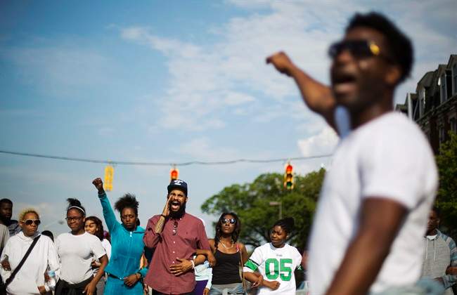 Protesters link arms while marching toward City Hall to demonstrate the police-custody death of Freddie Gray, Thursday, April 30, 2015, in Baltimore. (AP Photo/David Goldman).