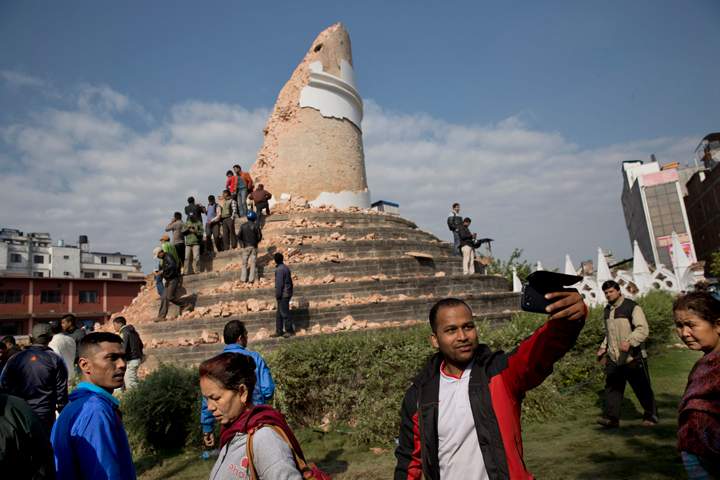 A man takes a selfie at the historic Dharahara Tower, a city landmark, that was damaged in Saturday’s earthquake in Kathmandu, Nepal, Monday, April 27, 2015.