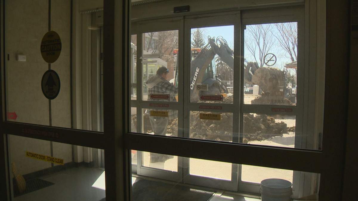 Crews work to dig up a six inch water main just outside Pioneer Village.