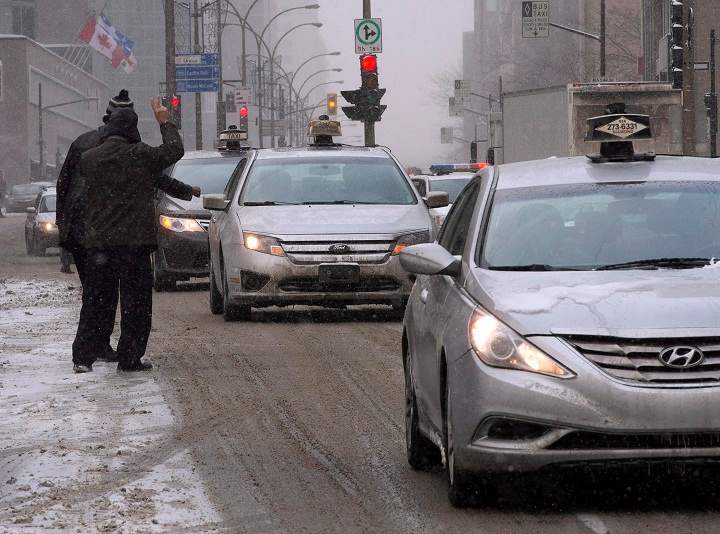 Taxi drivers make their way through downtown during a protest against unregulated transport services like Uber, Thursday, February 19, 2015 in Montreal.