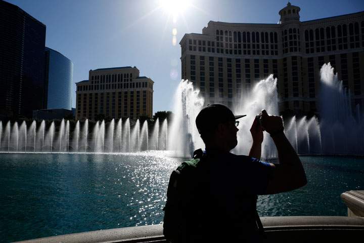In this April 15, 2015 photo, a man takes a picture of the fountains in front of the Bellagio hotel and casino in Las Vegas. Whether you're coming to Las Vegas for a convention, wedding or just a vacation, casinos are just one option, along with shopping, spas, food, nightlife, festivals and various other adventures.