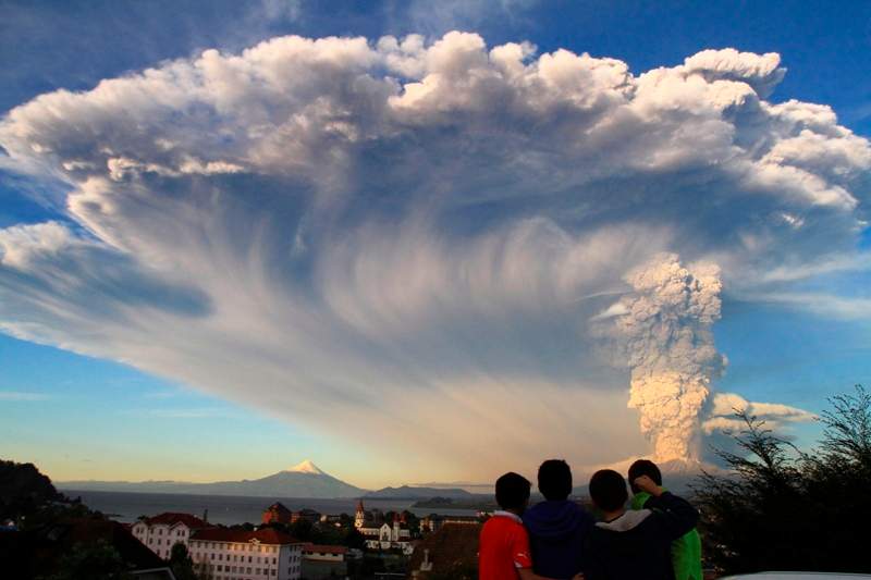 Children watch the Calbuco volcano erupt, from Puerto Varas, Chile, Wednesday, April 22, 2015. The volcano erupted billowing a huge ash cloud over a sparsely populated, mountainous area in southern Chile. Authorities ordered the evacuation of the inhabitants of the nearby town of Ensenada, along with residents of two smaller communities.