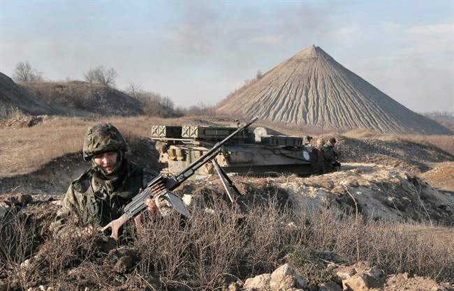 FILE - In this March 11, 2015, file photo, a Ukrainian serviceman takes position at the front line outside Kurahovo, in the Donetsk region of Ukraine.