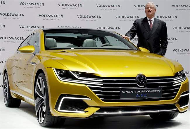 Volkswagen CEO Martin Winterkorn poses for the media beside a GTE concept car.