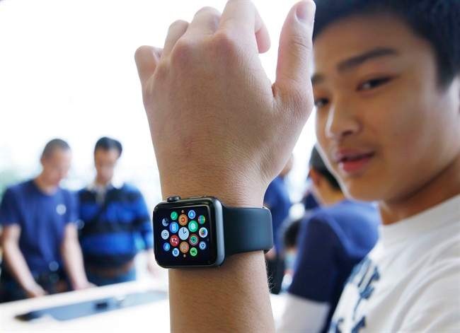 A customer tries on an Apple Watch at an Apple Store in Hong Kong Friday, April 10, 2015. From Beijing to Paris to San Francisco, the Apple Watch made its debut Friday. Customers were invited to try them on in stores and order them online.