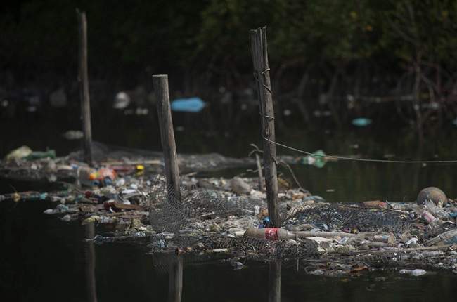In this Feb. 28, 2015 file photo, trash floats on the water along a fence line in the Guanabara Bay in Rio de Janeiro, Brazil. The world governing body of sailing threaten Friday, April 24, 2015, to move events for the Rio 2016 Olympics out of the city\’s polluted Guanabara Bay unless \”a whole lot more is done very quickly\” to clear the venue of floating debris and sewage.