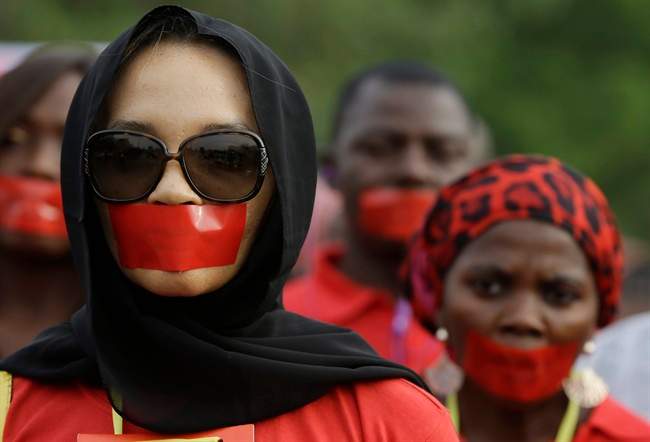 People march during a silent protest calling on the government to rescue the kidnapped girls of the government secondary school in Chibok, who were abducted a year ago, in Abuja, Nigeria, Monday, April 13, 2015. 