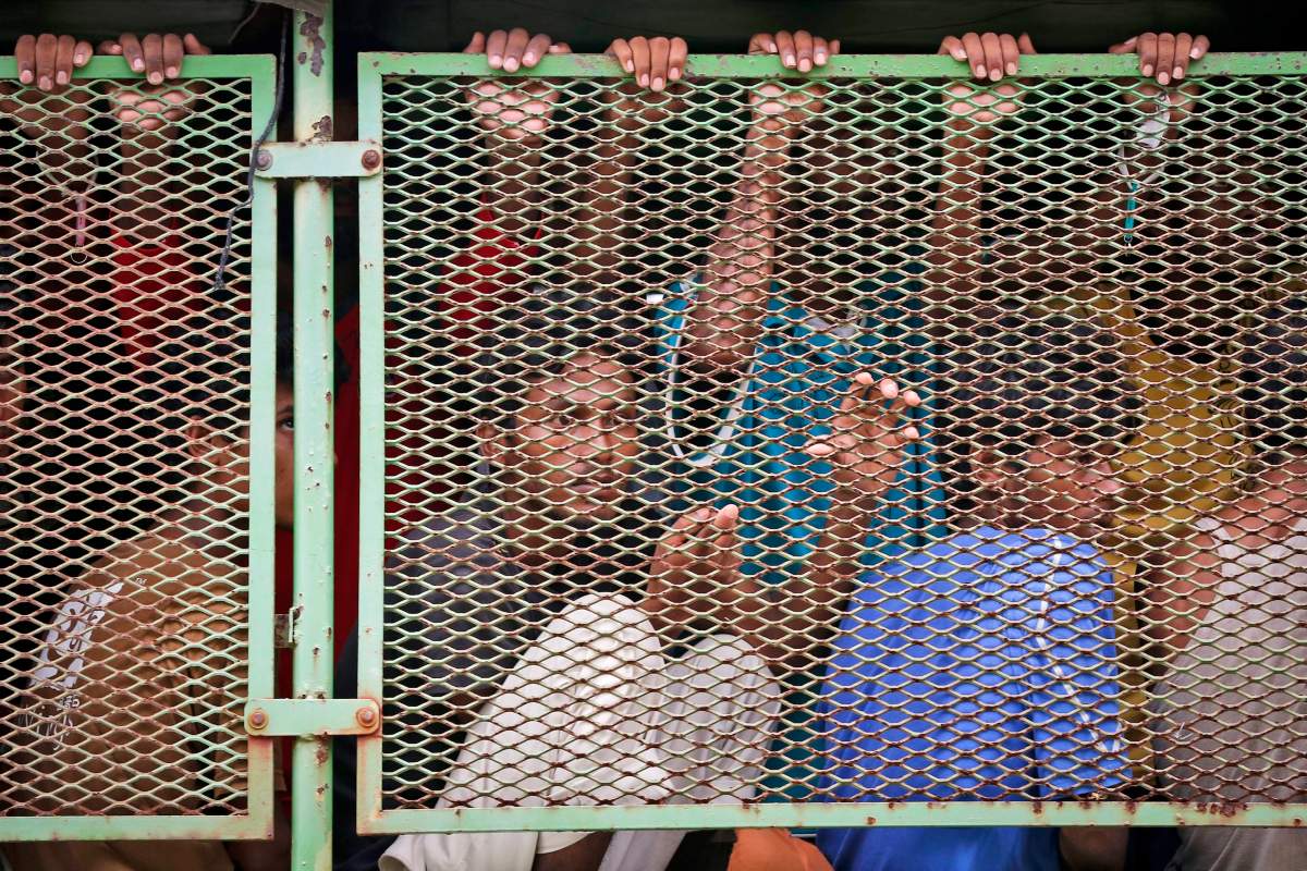 Migrants ride on a truck as they are transferred from a temporary detention facility to a naval base on Langkawi island, Malaysia, on Wednesday, May 13, 2015, before being moved to a detention center on the Malaysian mainland.