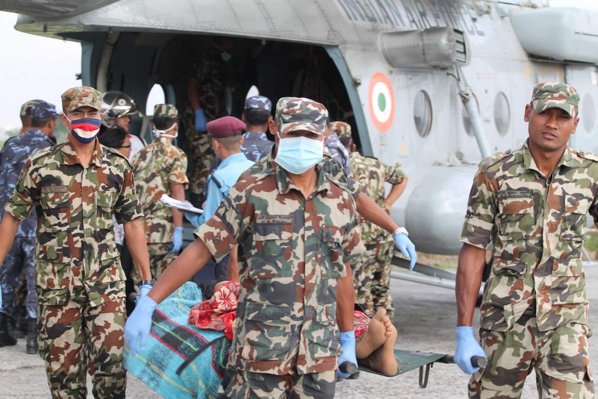 Nepalese Army personnel carry injured earthquake survivors from Dolakha district out of an Indian Air Force helicopter at Tribhuvan International Airport in Kathmandu on May 19, 2015.