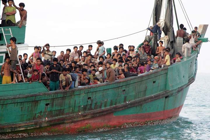 FILE - In this Wednesday, May 20, 2015 file photo, migrants sit on their boat as they wait to be rescued by Acehnese fishermen on the sea off East Aceh, Indonesia. Many of the thousands of migrants abandoned at sea in Southeast Asia this month are Rohingya Muslims who fled their home country of Myanmar. The Rohingya are a Muslim minority in predominantly Buddhist Myanmar, also known as Burma. Numbering around 1.3 million, they are concentrated in western Rakhine state, which neighbors Bangladesh. (AP Photo/S. Yulinnas, File).