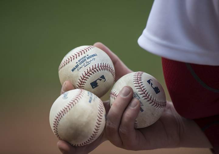 A ball boy has baseballs at the ready during the first inning between the Boston Red Sox and Toronto Blue Jays at Fenway Park in Boston, Massachusetts on April 29, 2015.