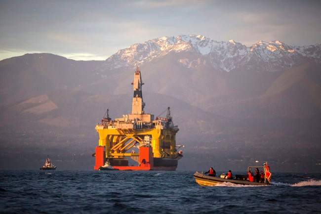 In this April 17, 2015 file photo, with the Olympic Mountains in the background, a small boat crosses in front of an oil drilling rig as it arrives in Port Angeles, Wash. 