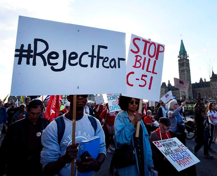 People rally against Bill C-51, the government's anti-terror legislation, as they pass Parliament Hill during a International Workers' Day protest against austerity measures in Ottawa on Friday, May 1, 2015.