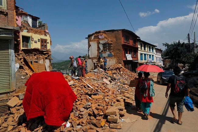 Nepalese people salvage belongings from the debris of their house damaged in last week earthquake in Chautara, Sindhupalchok district, Nepal, Saturday, May 2, 2015.