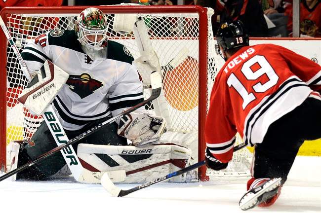 Minnesota Wild goalie Devan Dubnyk, left, fails to stop a shot and goal by Chicago Blackhawks center Jonathan Toews, right, during the second period of Game 2 in the second round of the NHL Stanley Cup hockey playoffs in Chicago, Sunday, May 3, 2015.