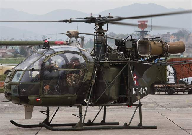 A Nepalese army chopper carrying rescuers lands at the airport in Kathmandu, Nepal, Friday, May 15, 2015.